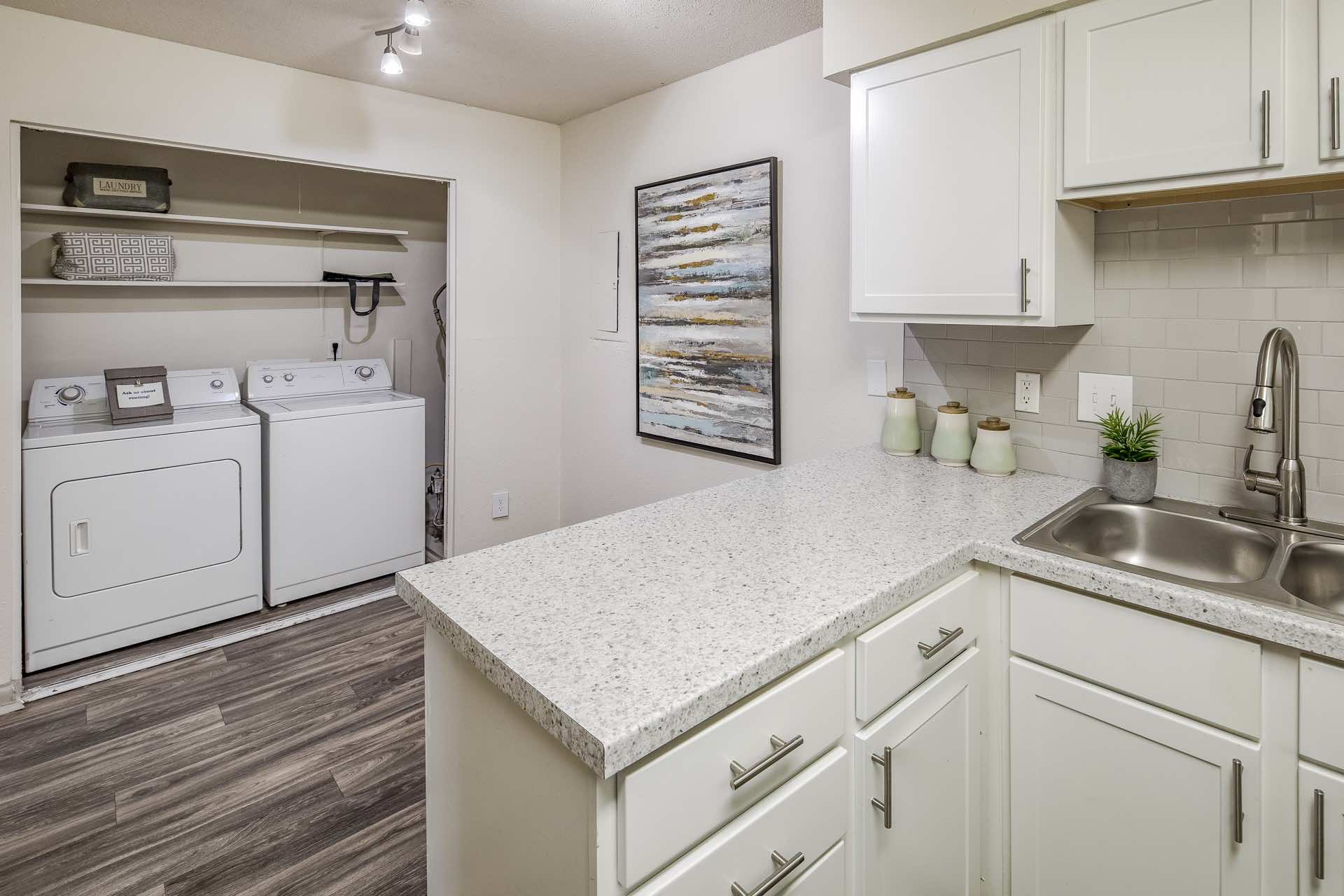 kitchen opens to laundry room with full-size washer and dryer